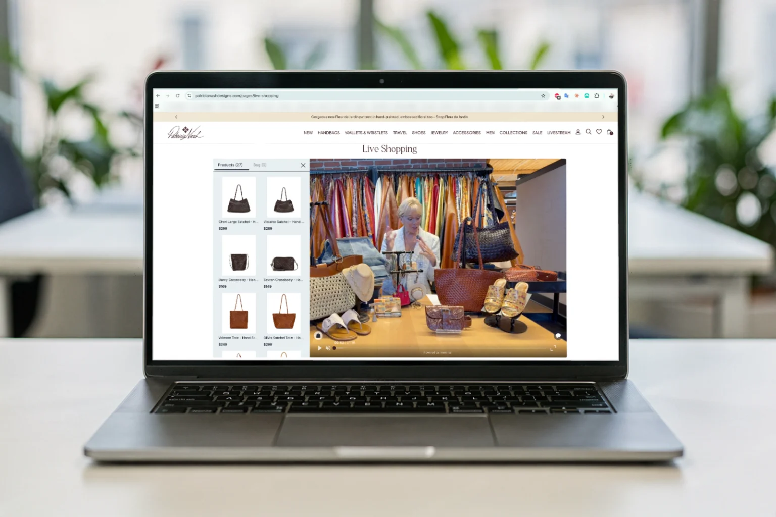 Patricia Nash's live-shopping page open on a laptop: a recorded show playing beside a scrollable grid of twenty-seven shoppable products.