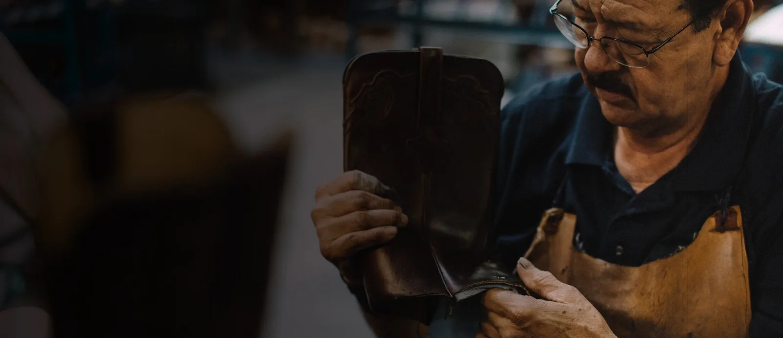 A bootmaker finishing a Lucchese boot by hand.