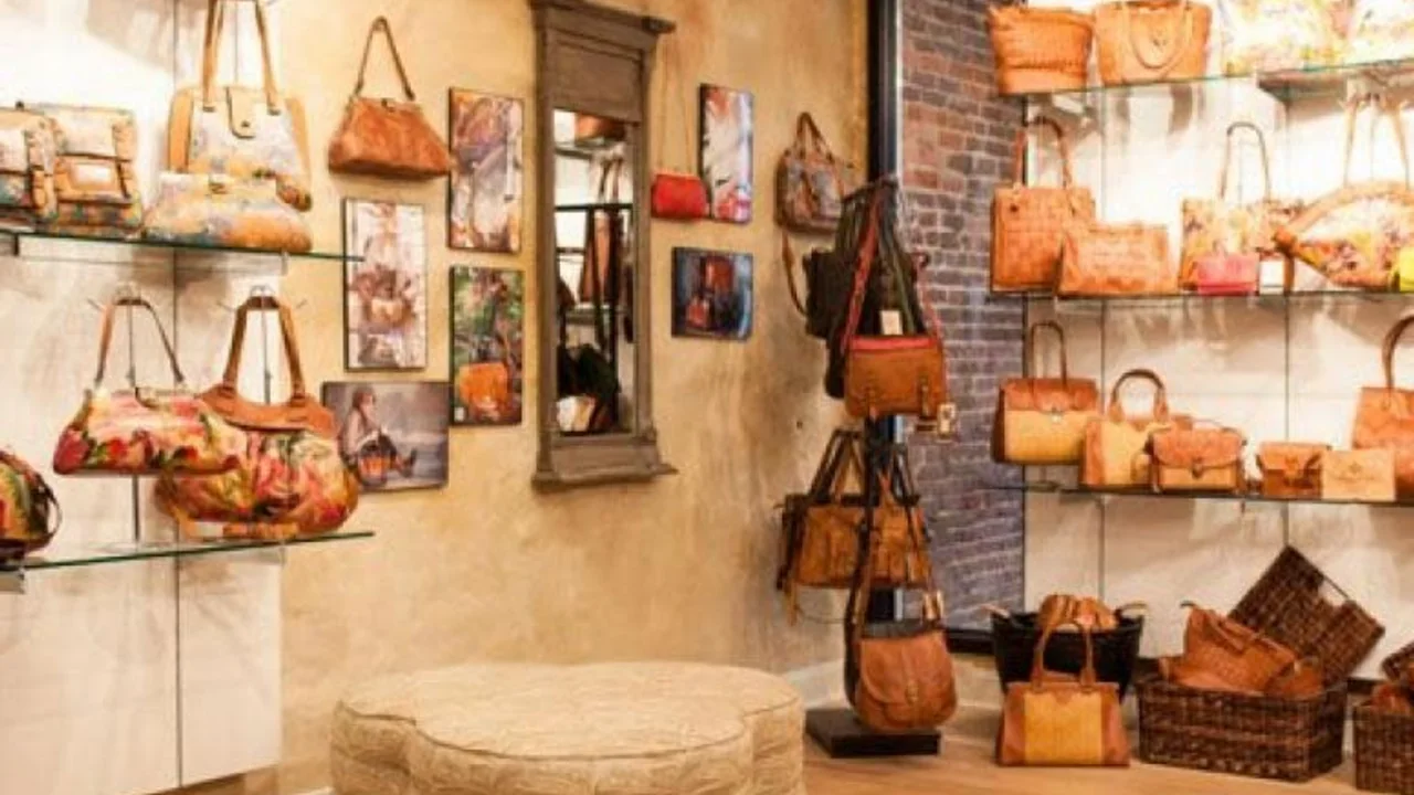 Patricia Nash's showroom: hand-painted leather handbags on glass shelves against a plaster wall.